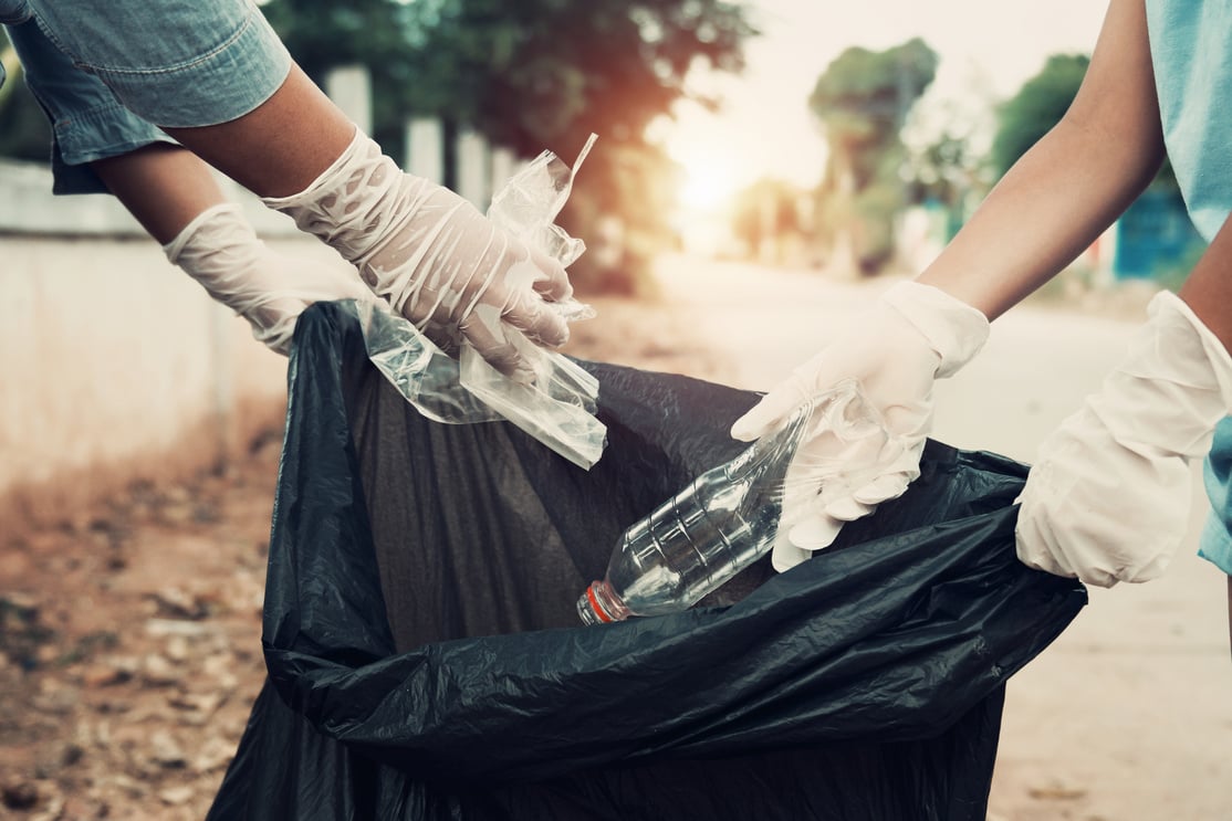 Mother and child help picking up trash at park